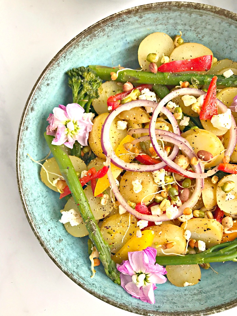 A bowl of mango, Lime and Chilli Potatoes with onion, peppers and tenderstem broccoli.