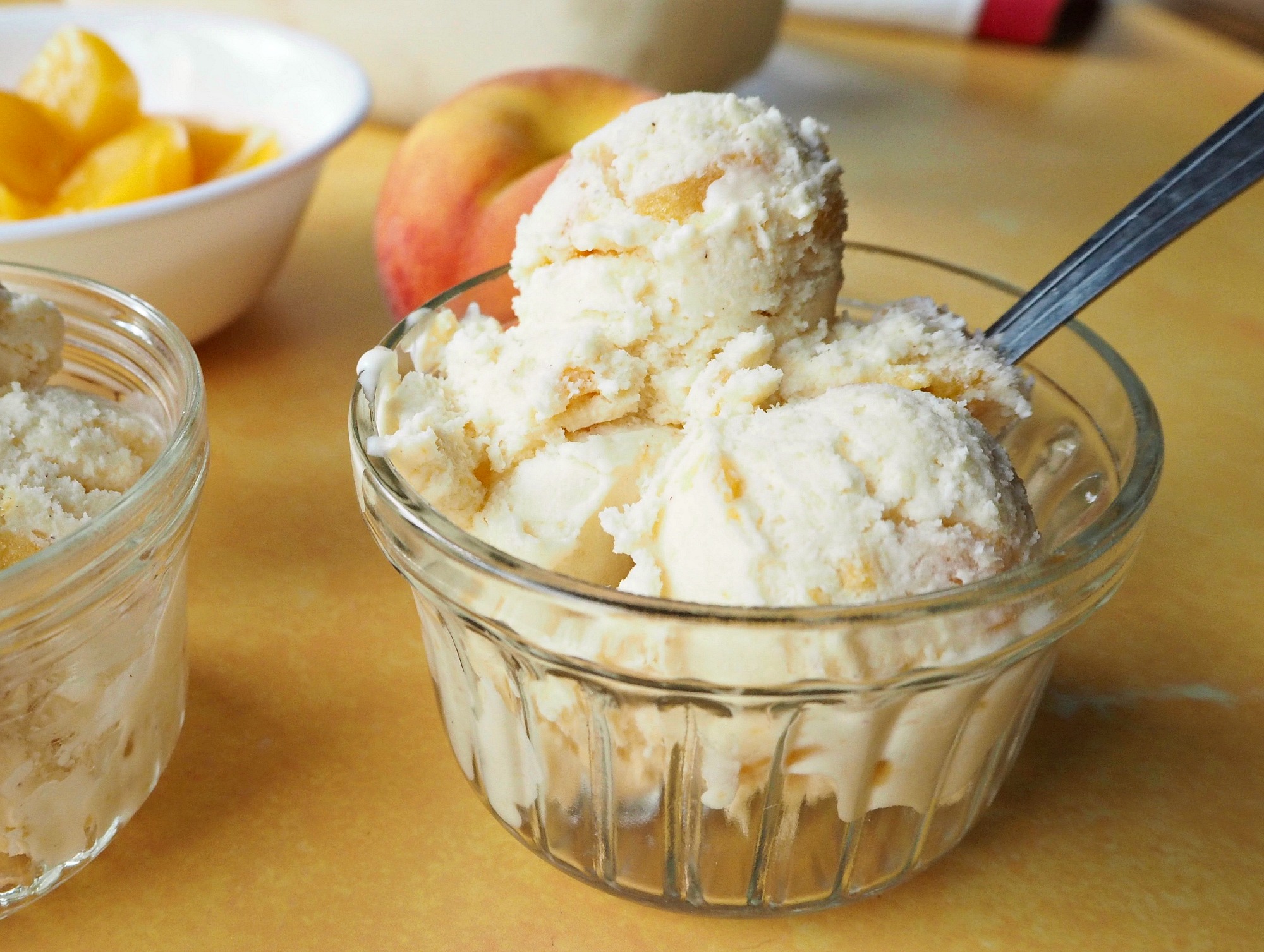 A glass bowl of homemade peach ice cream