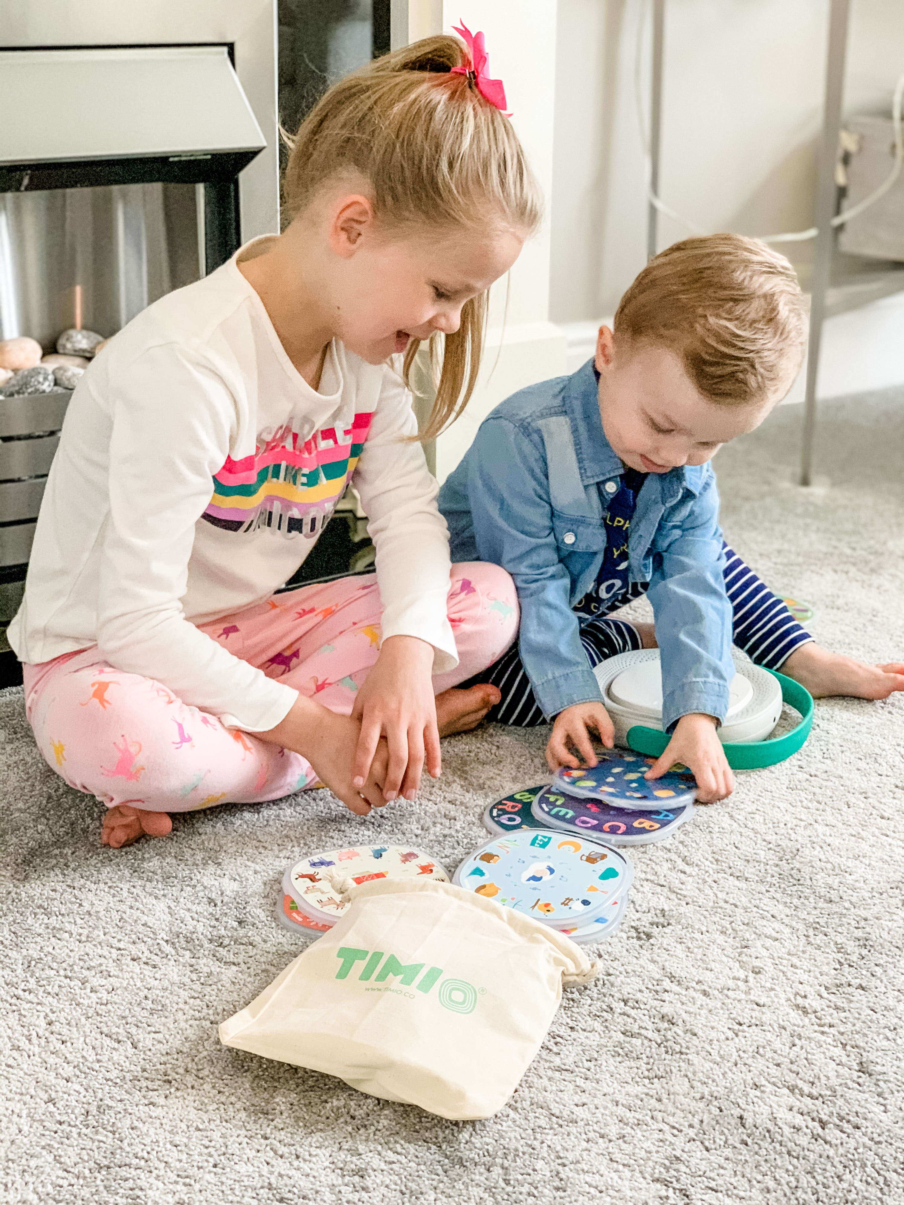 A boy and a girl playing with a kid's audio and music player for learning