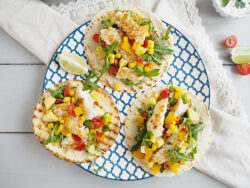 Three fish tacos on a plate.