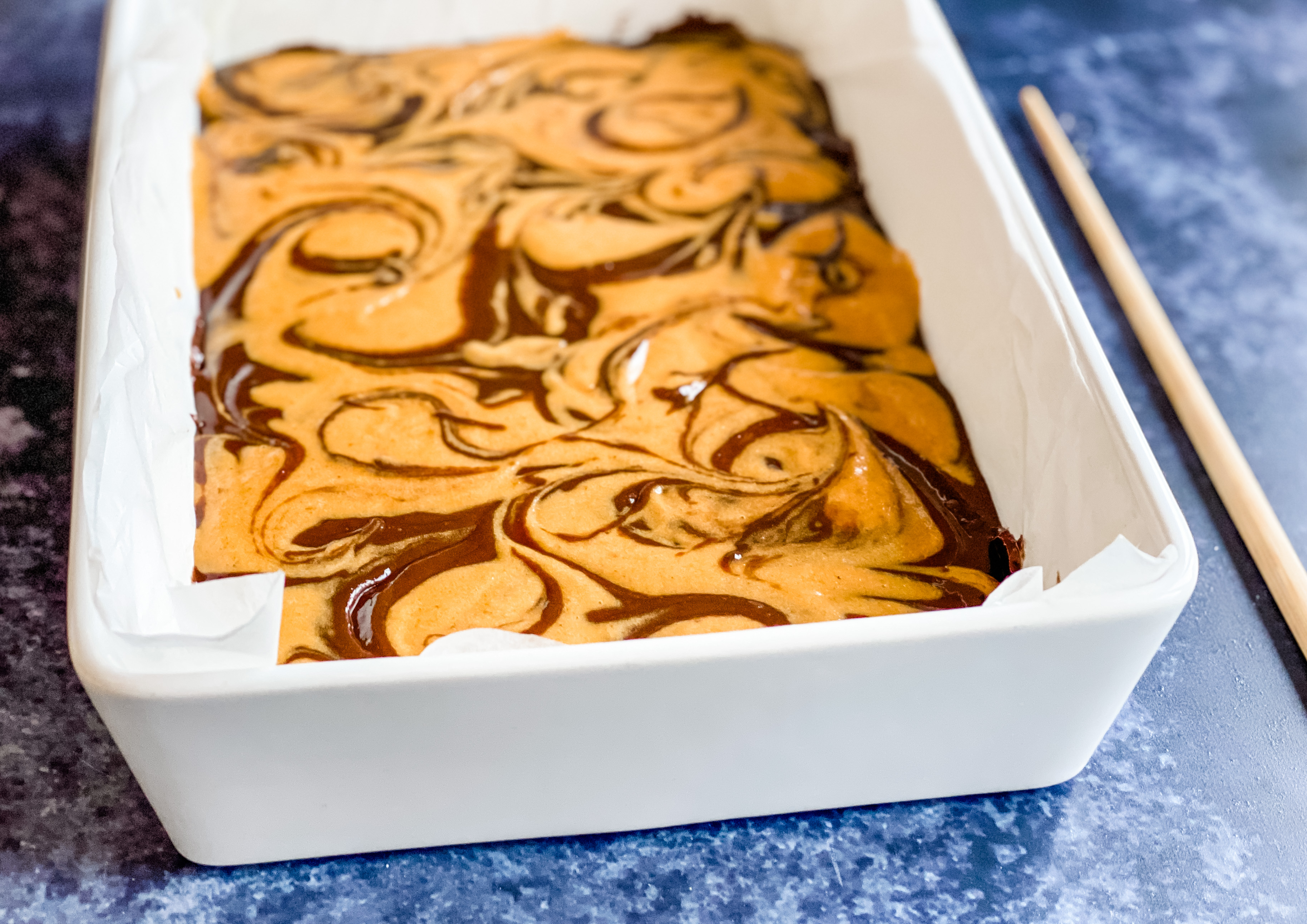 A tray of uncooked pumpkin brownies ready for the oven