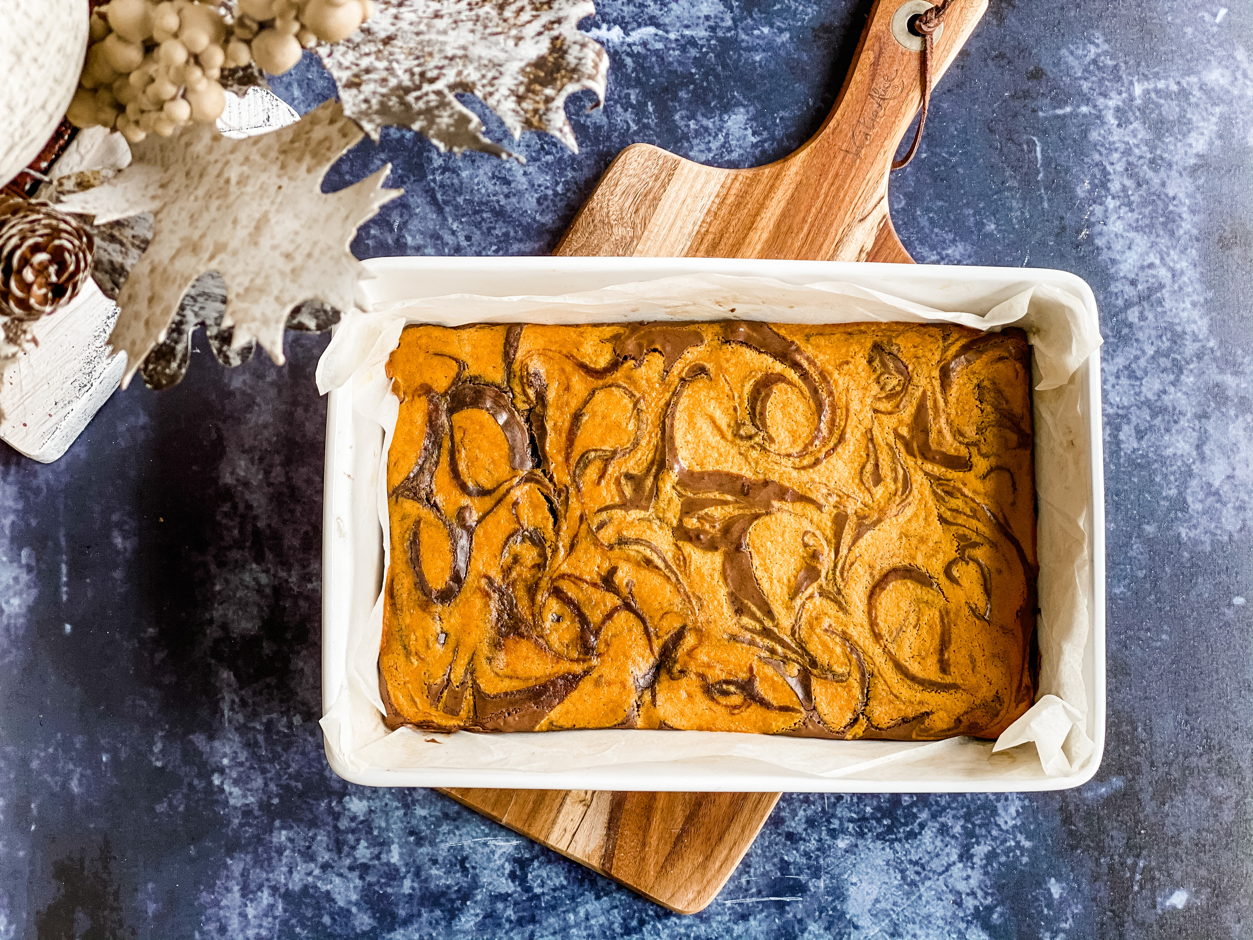 A tray of marbles chocolate pumpkin brownies on a wooden board