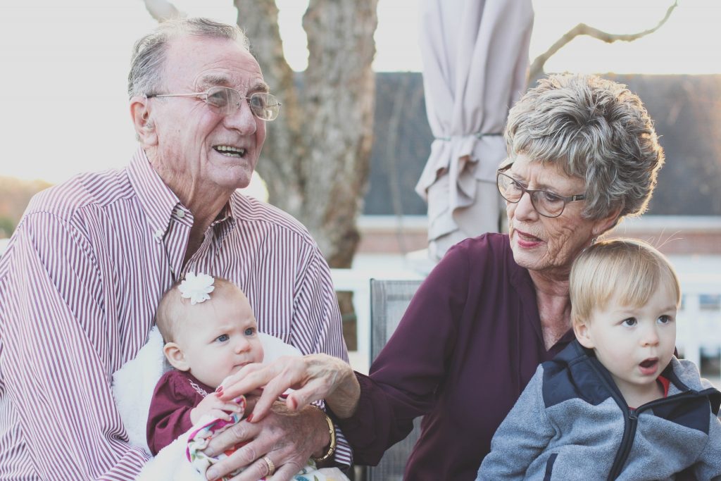 Grandparents holding a young boy and baby girl