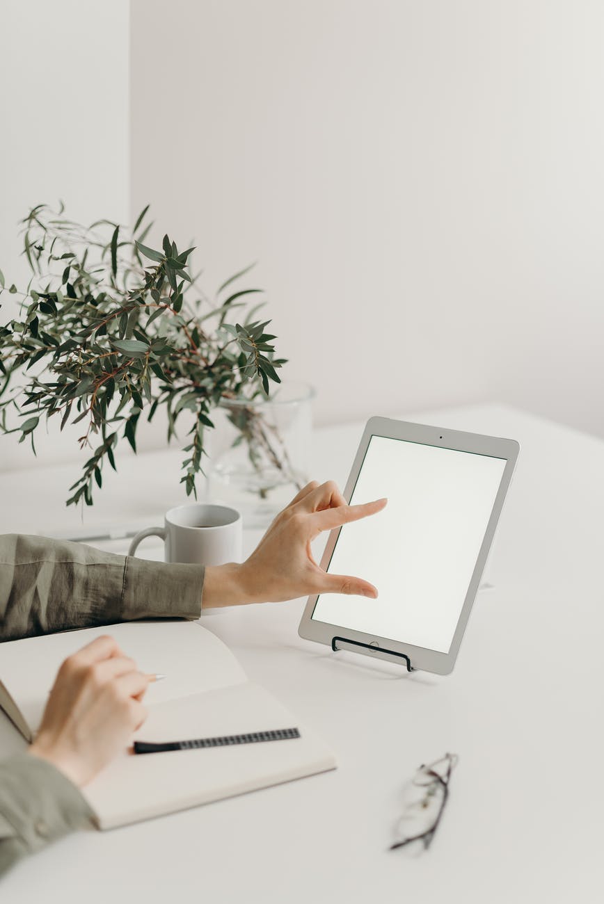 person holding white tablet computer