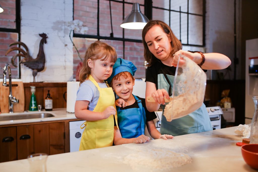 A mother baking with 2 young children