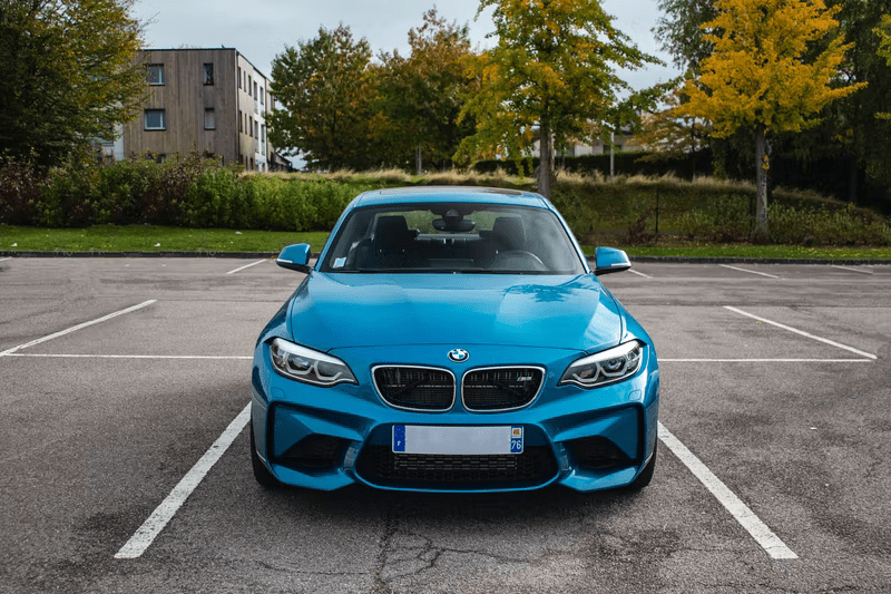 A bright blue car parked in an empty car park