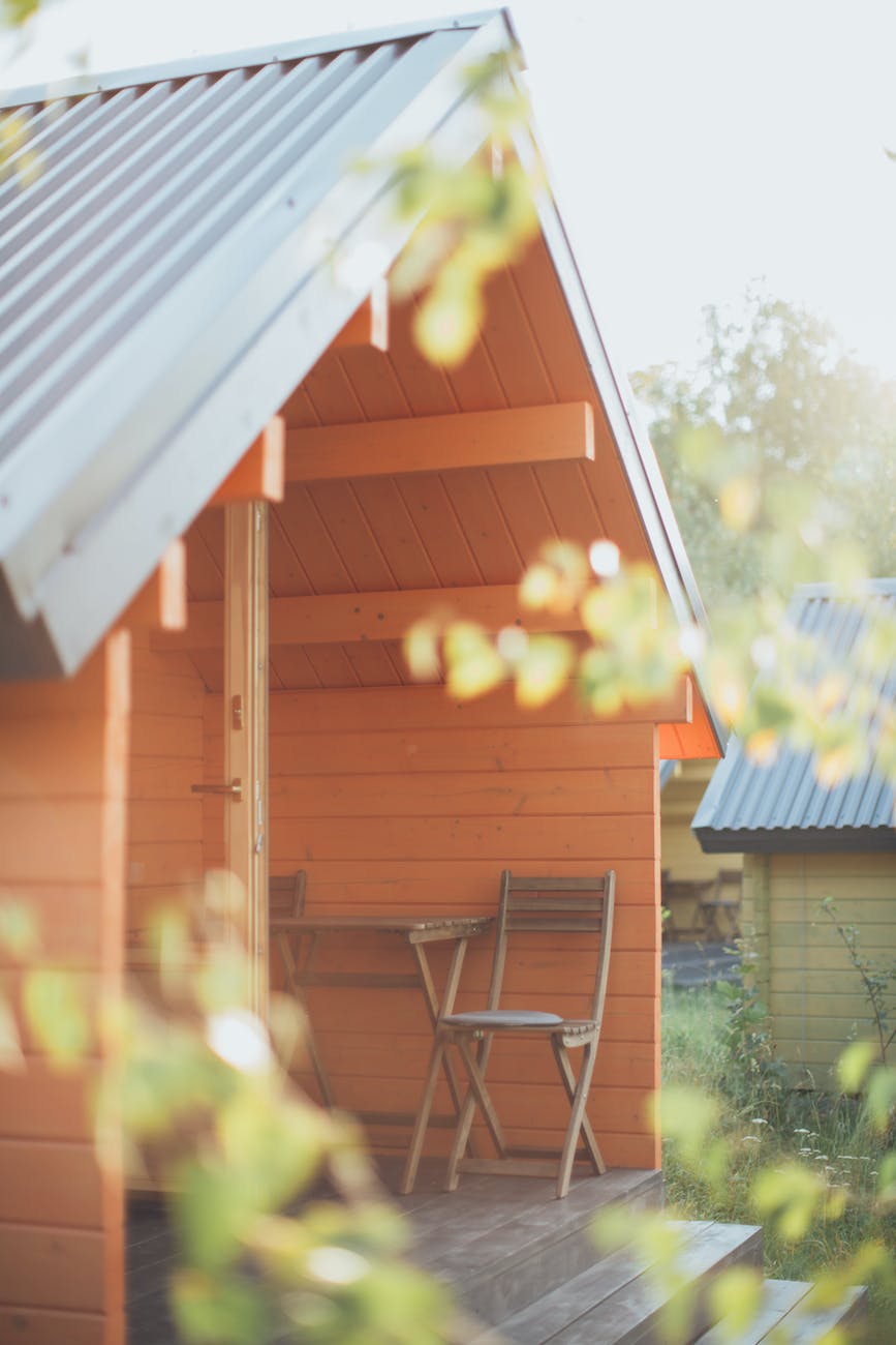 chair beside table in front of an orange wooden shed