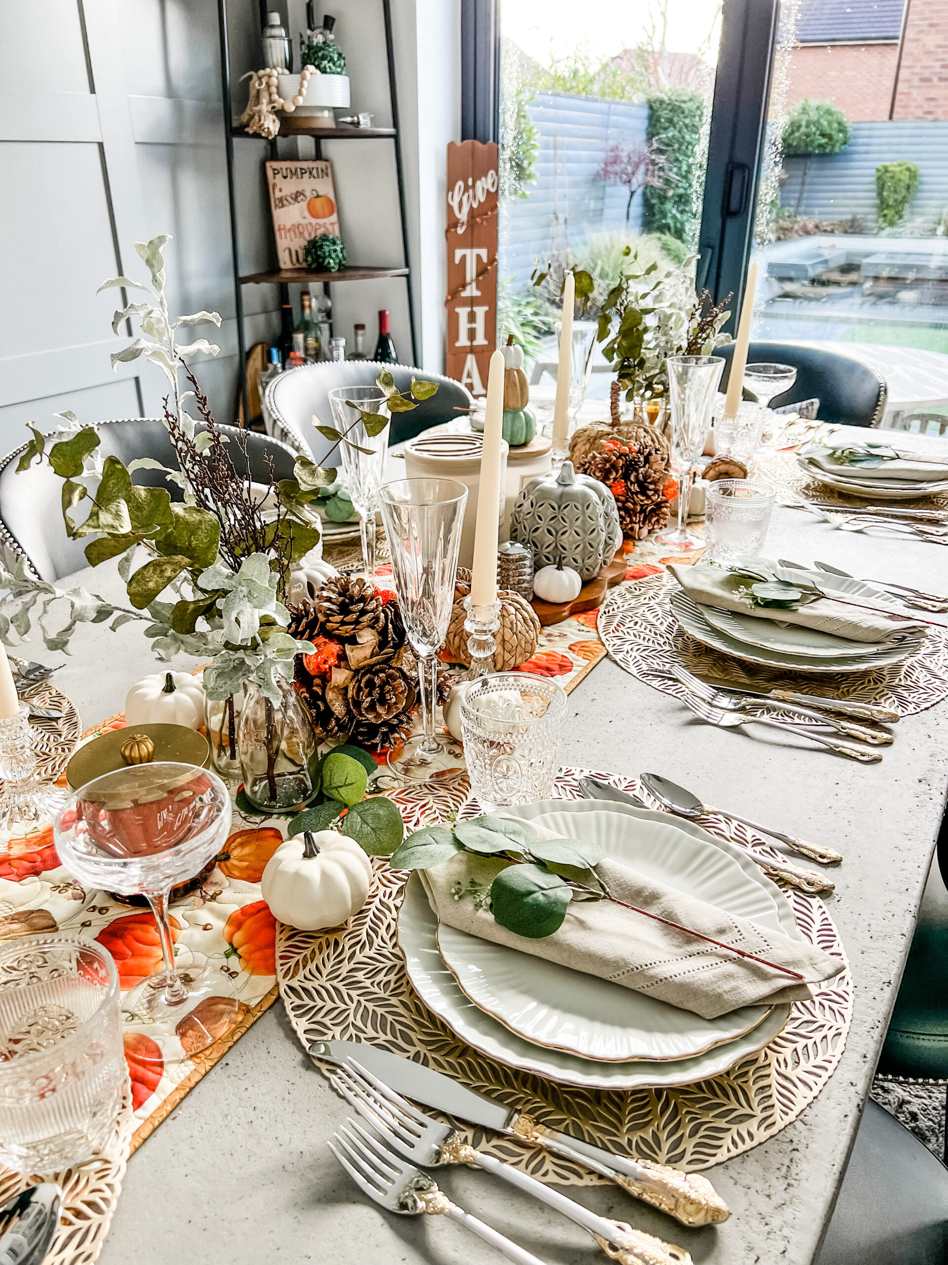 Thanksgiving tablescape with pumpkins and leaves and pinecones