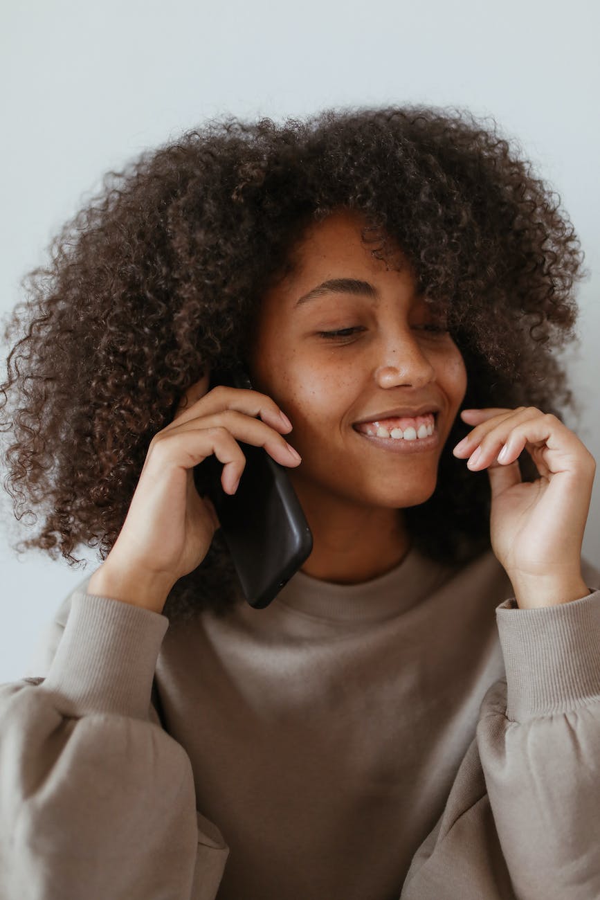 a woman wearing a brown sweater on a phone call