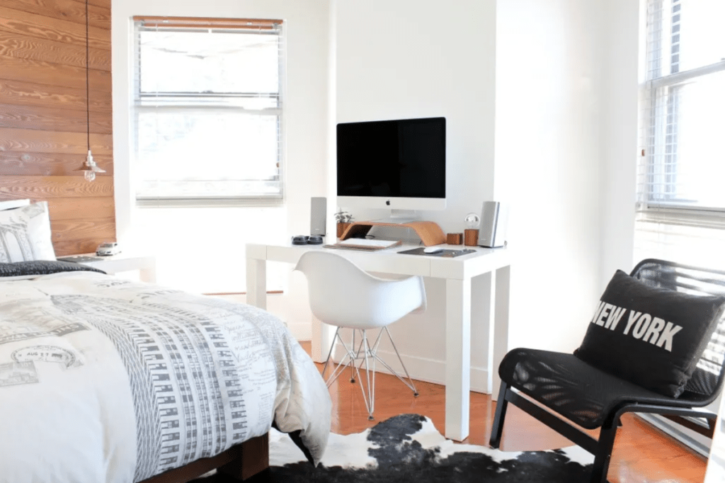 A bedroom with a desk and a screen on it