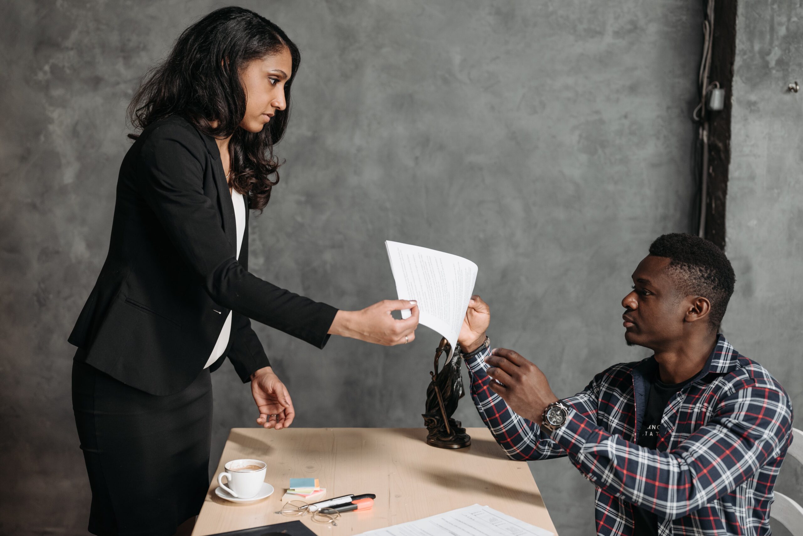 A man is hiring a family lawyer and giving the woman a piece of paper.
