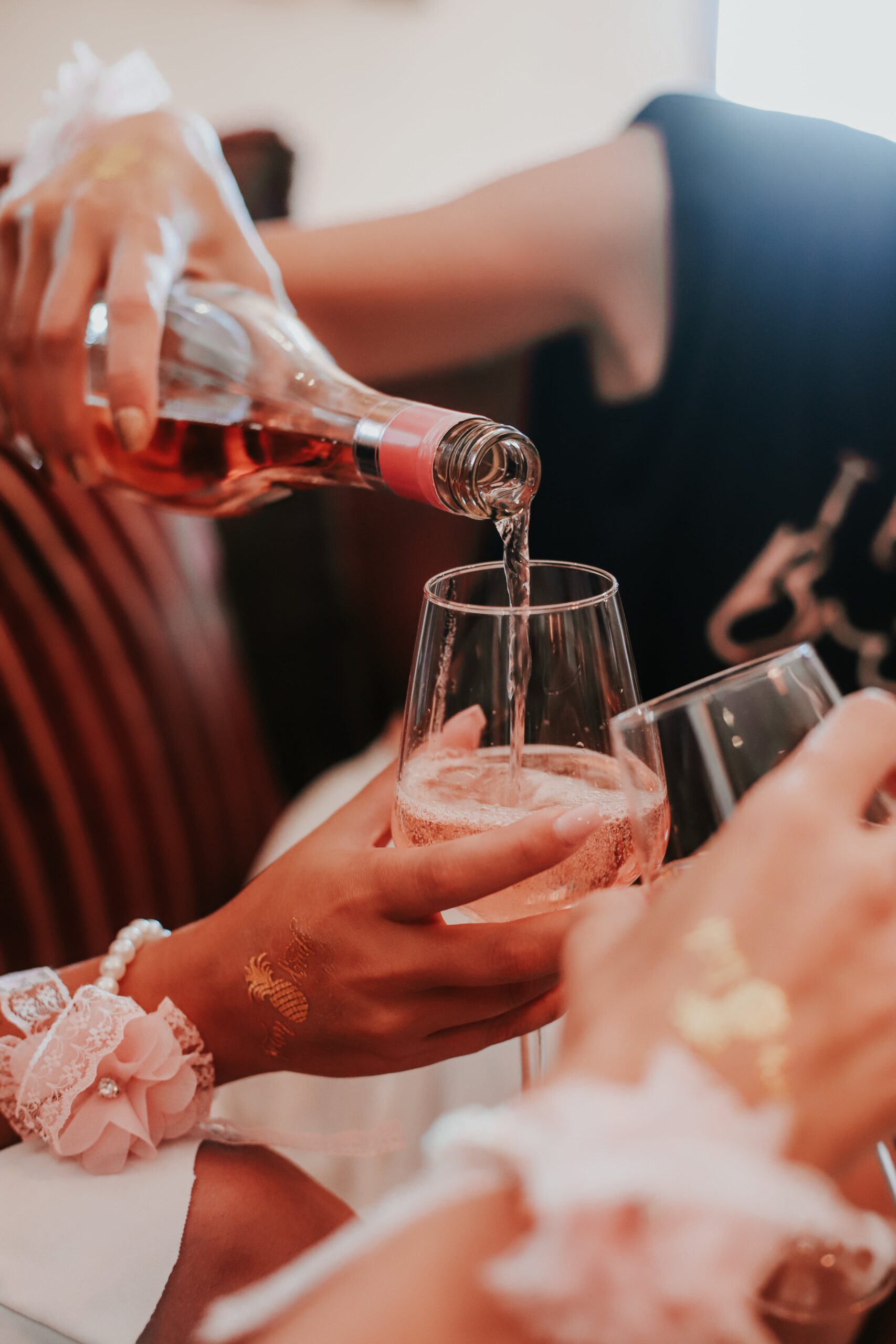 A5448249-A949-471F-A5BD-A3C0AB15D0FE A group of women are **celebrating Galentine's Day** by pouring a glass of wine.