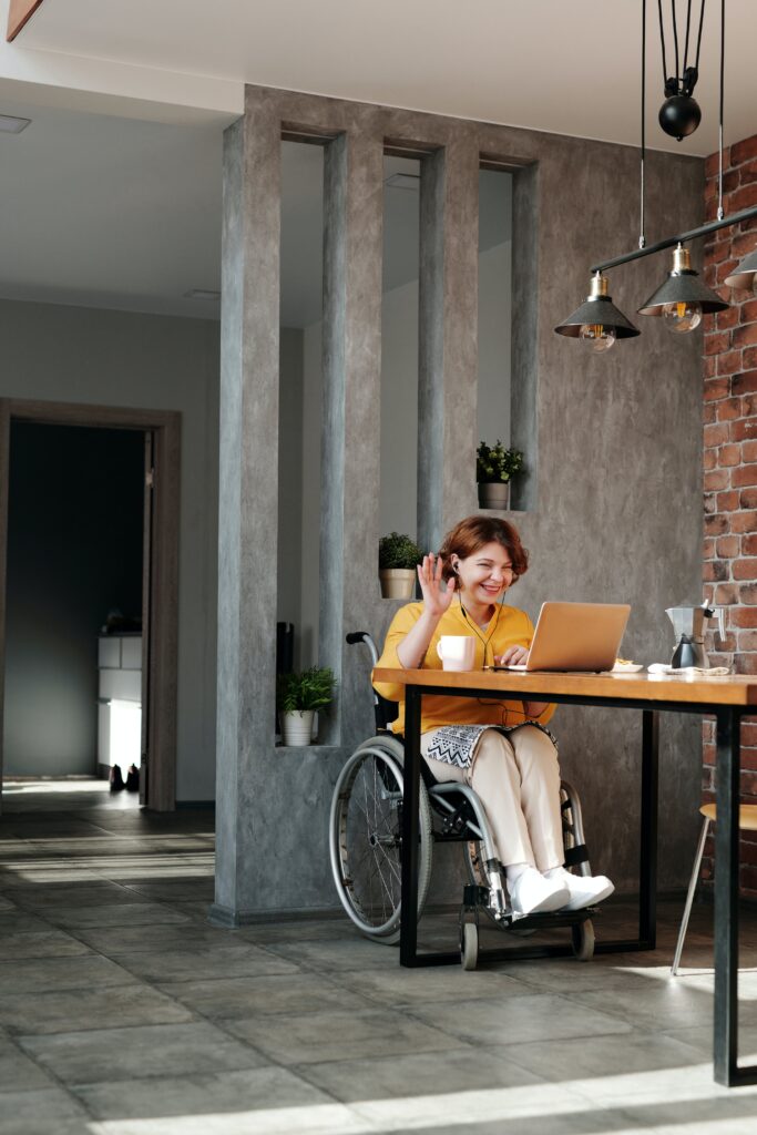 A woman in a wheelchair ensuring accessibility laws on her laptop.