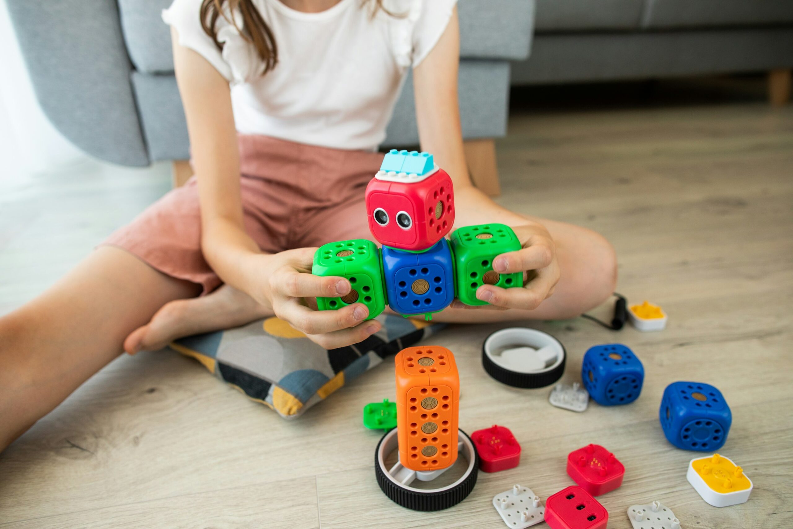 A girl engaging in inclusive play with a toy robot.
