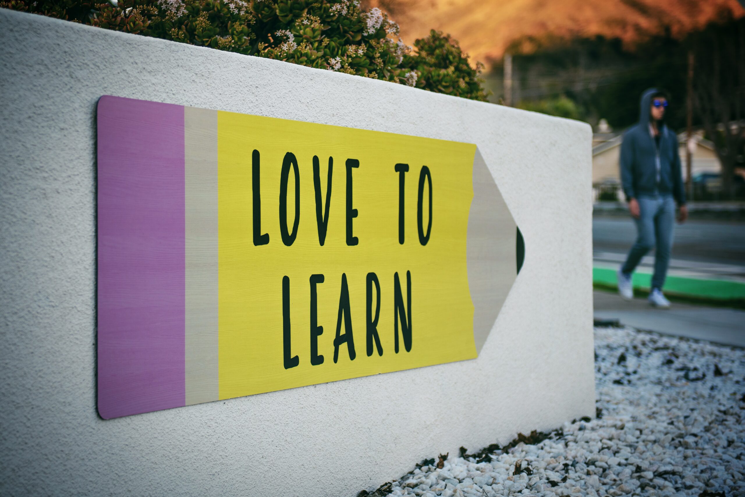 A language learning sign on a wall featuring the Rosetta Stone.