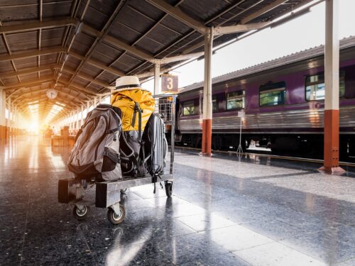 A man with a backpack at a train station left luggage storage area.