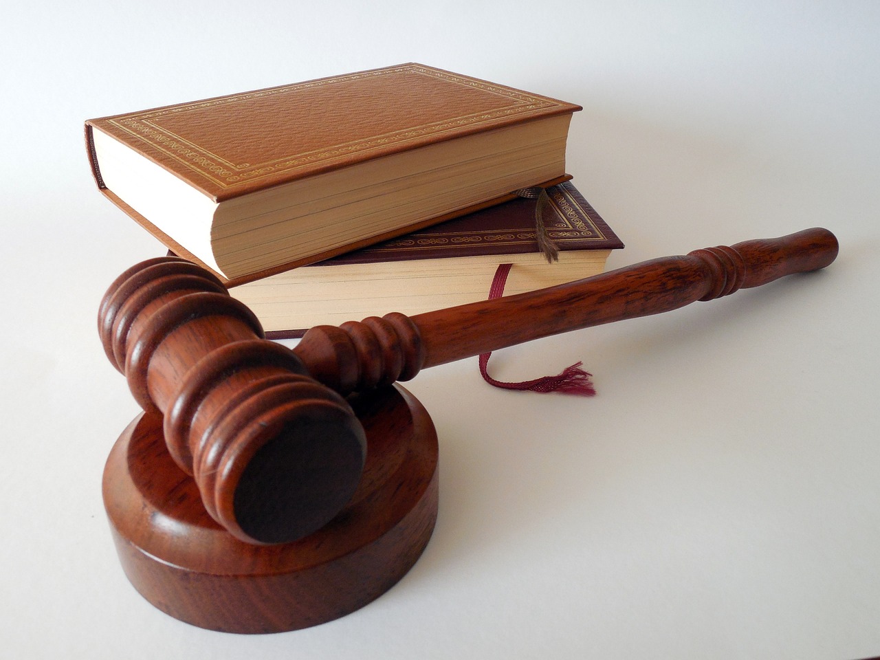 A wooden gavel sits on top of a book, symbolizing the importance of the family's case in need of hiring a lawyer.