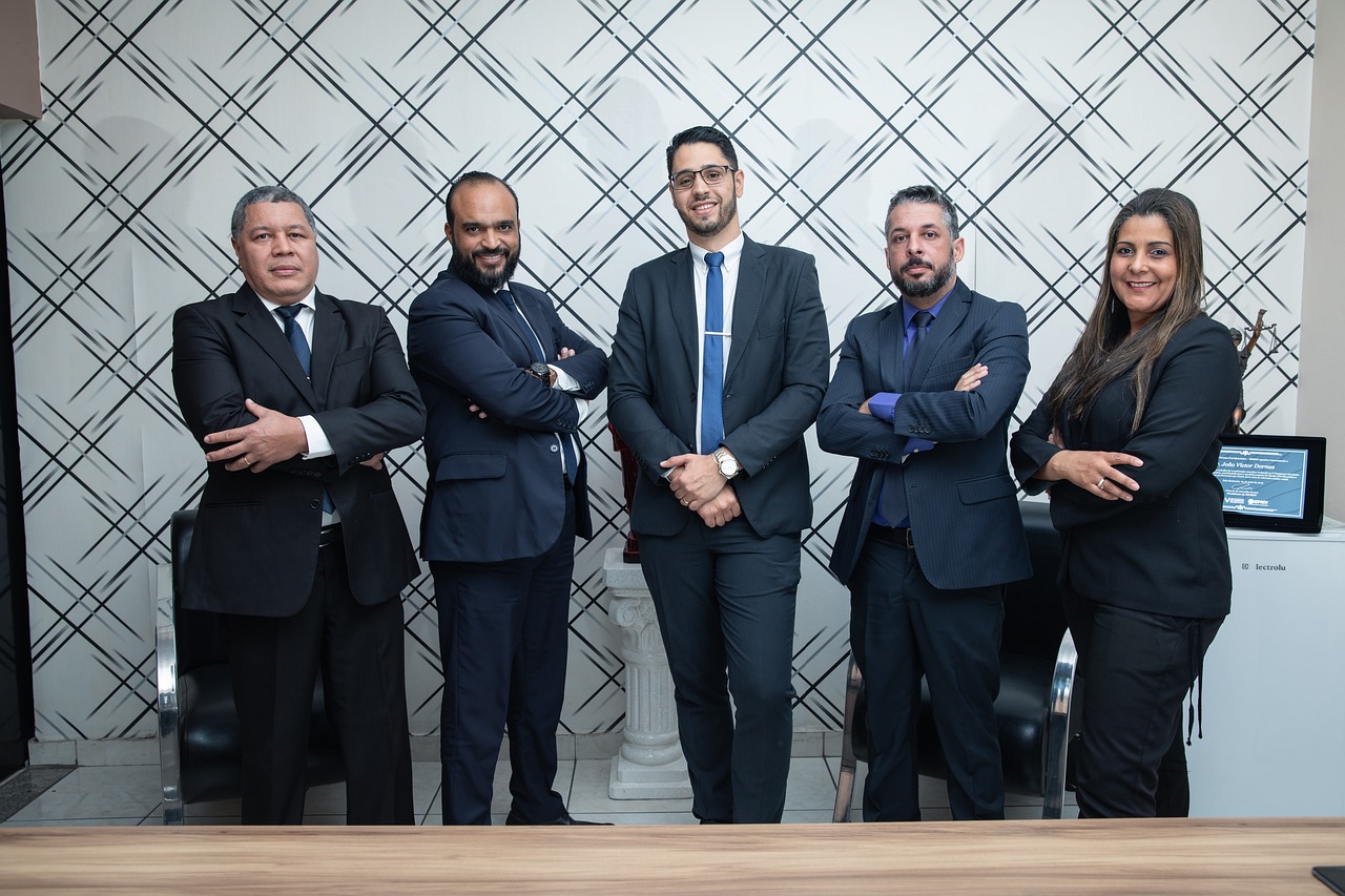A group of business people standing in front of a desk discussing an auto draft payment system.