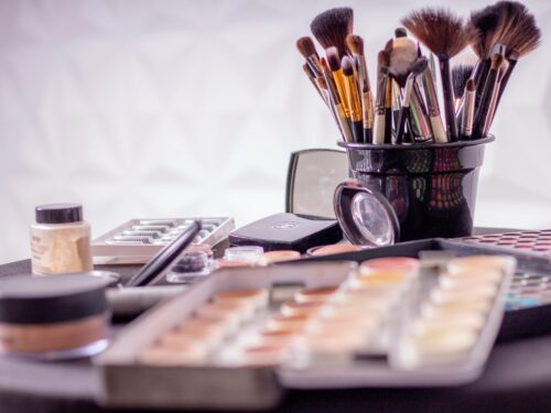 Makeup brushes and cosmetics tips on a table for busy moms.