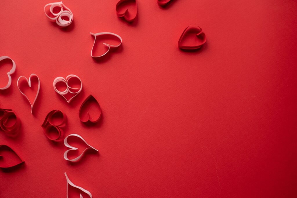 Love-filled Valentine's day paper hearts on a red background.