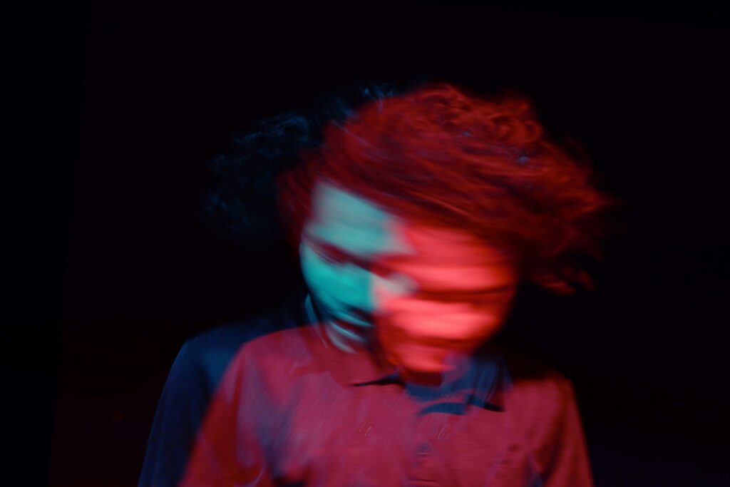 A blurry image of a person with curly hair.
