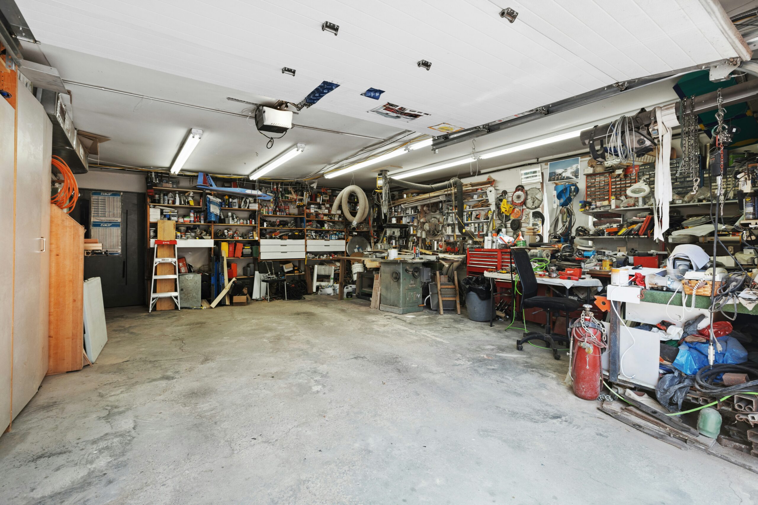 A well-used garage workshop cluttered with various tools and equipment.